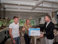 Ged.De Witte biedt de voucher aan aan Anne-Sophie Kat en Peter Kamphuis van camping De Kleine Wolf.