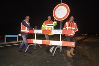 mensen met stopbord voor wegafsluiting